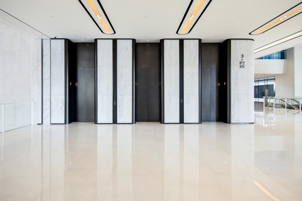 Modern commercial elevator lobby with multiple lift doors and sleek interior design